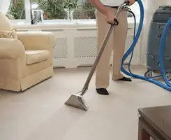 Carpet cleaning professional removing dirt and stains with a hot-water extraction tool in a home, Seattle, WA.