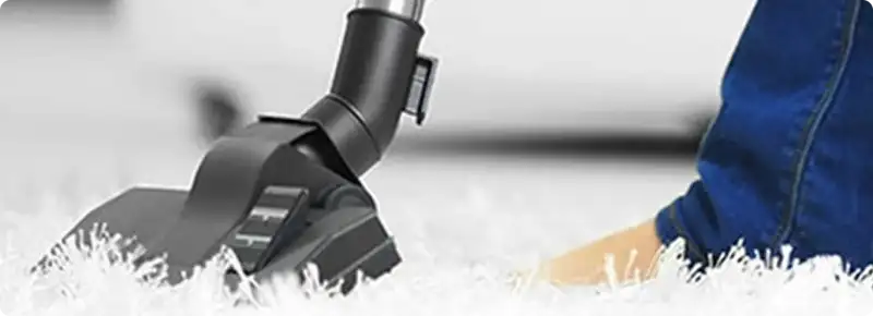 Close-up of a professional vacuuming a white carpet in Bothell.